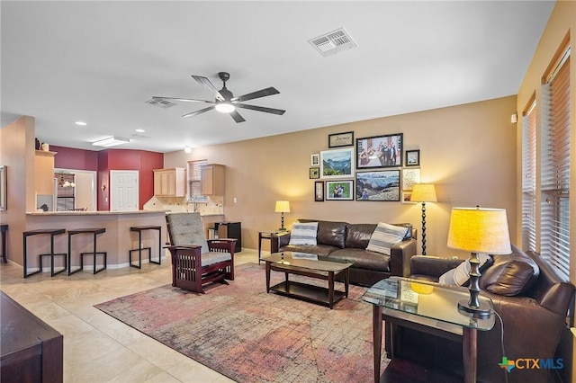 living room featuring a ceiling fan, visible vents, light tile patterned floors, and recessed lighting