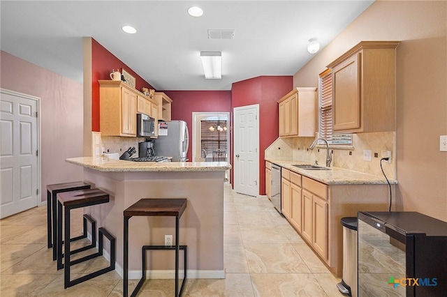 kitchen with a sink, appliances with stainless steel finishes, light brown cabinets, and visible vents
