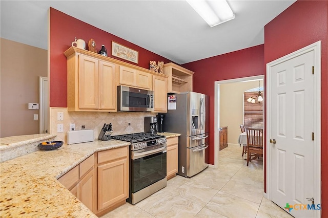 kitchen featuring an inviting chandelier, light brown cabinets, decorative backsplash, and stainless steel appliances