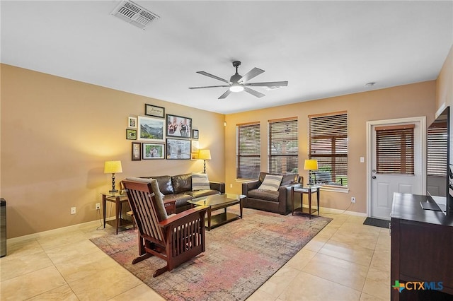 living area featuring baseboards, ceiling fan, visible vents, and light tile patterned floors