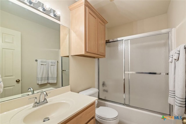 full bathroom with vanity, combined bath / shower with glass door, and toilet