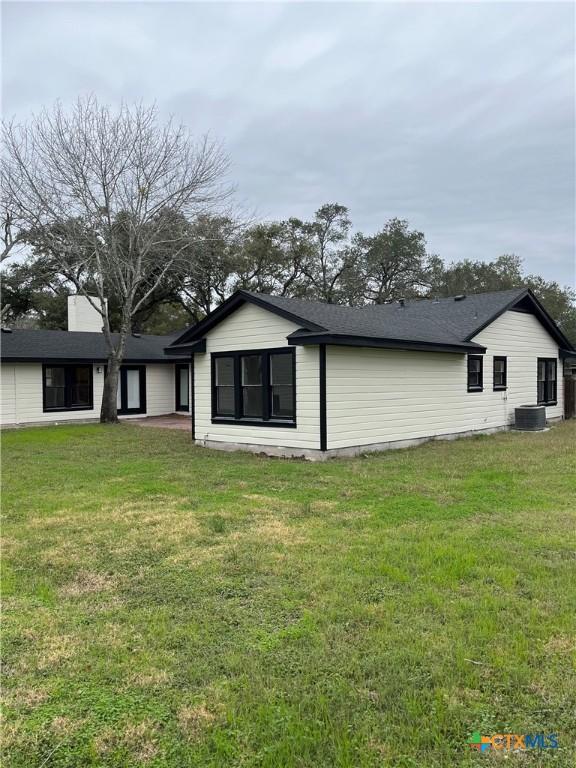 back of house featuring a lawn