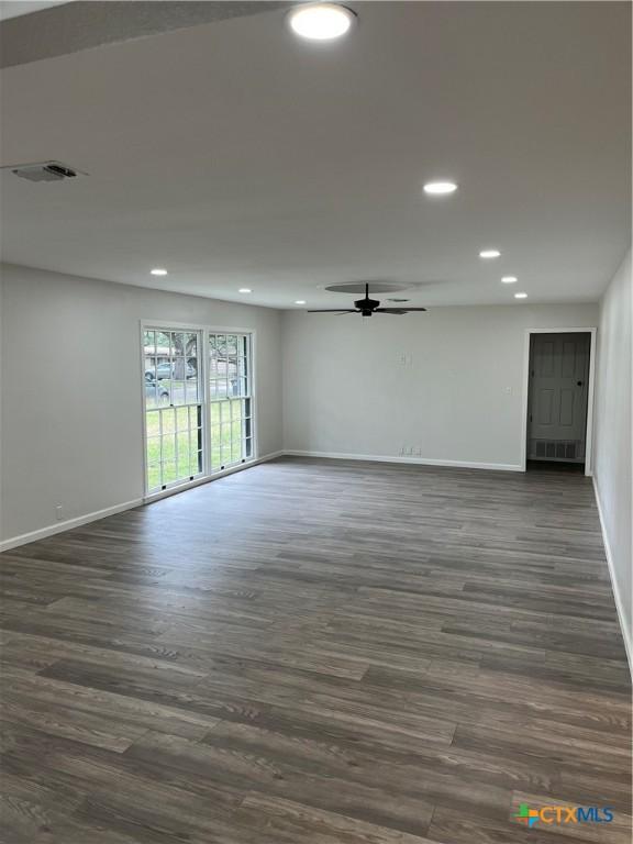 unfurnished room with ceiling fan and dark hardwood / wood-style flooring