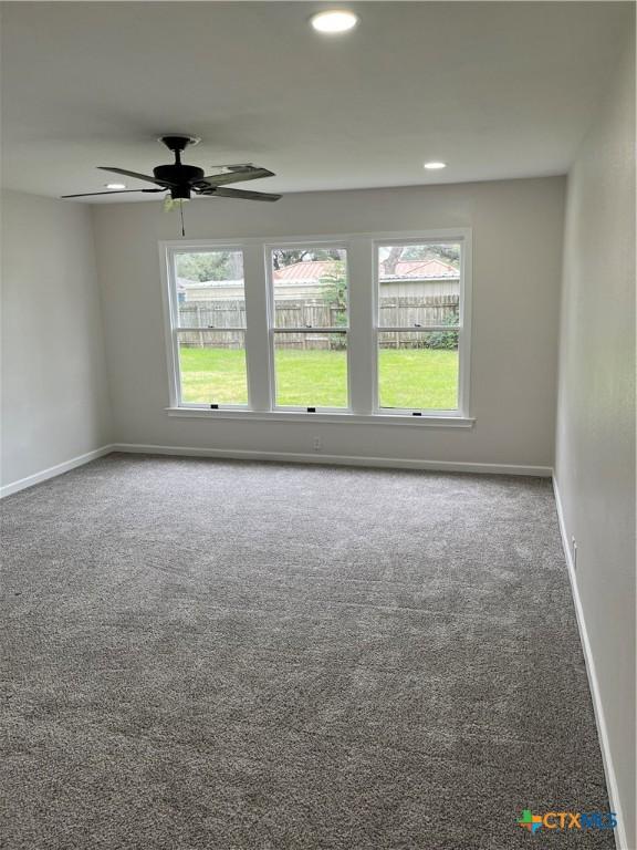 carpeted spare room with a healthy amount of sunlight and ceiling fan