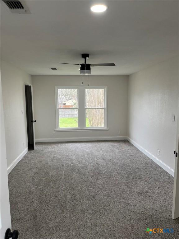 empty room with ceiling fan and carpet