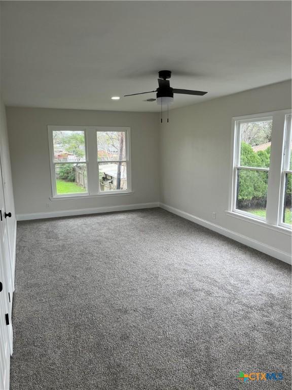 carpeted empty room featuring ceiling fan