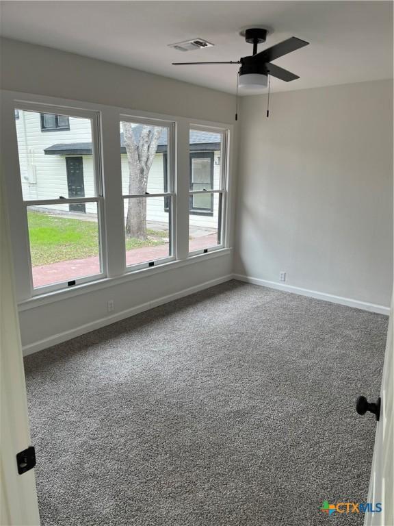 spare room with ceiling fan and carpet