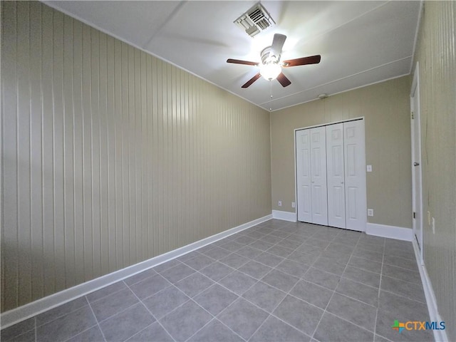 unfurnished bedroom with ceiling fan, a closet, and light tile patterned floors