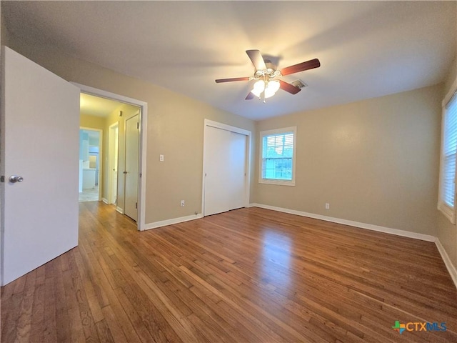 unfurnished bedroom with hardwood / wood-style flooring, a closet, and ceiling fan