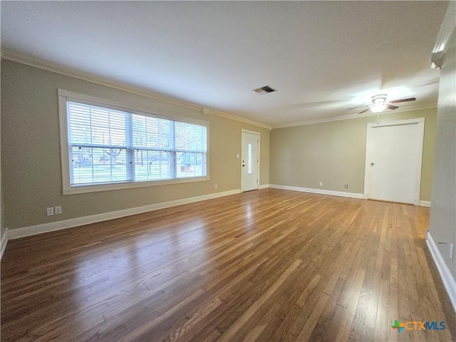 empty room with hardwood / wood-style flooring, ornamental molding, and ceiling fan