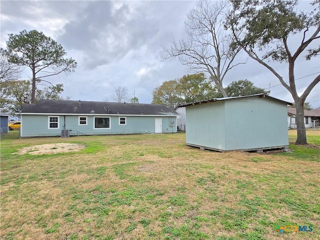 rear view of house with a storage shed and a yard