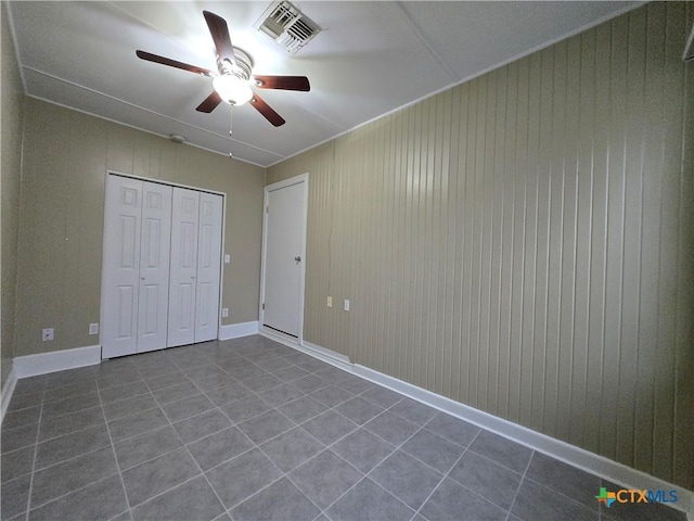 unfurnished bedroom with ceiling fan, tile patterned floors, and a closet