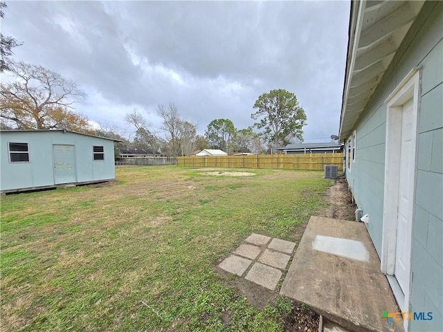 view of yard featuring central AC and a storage unit