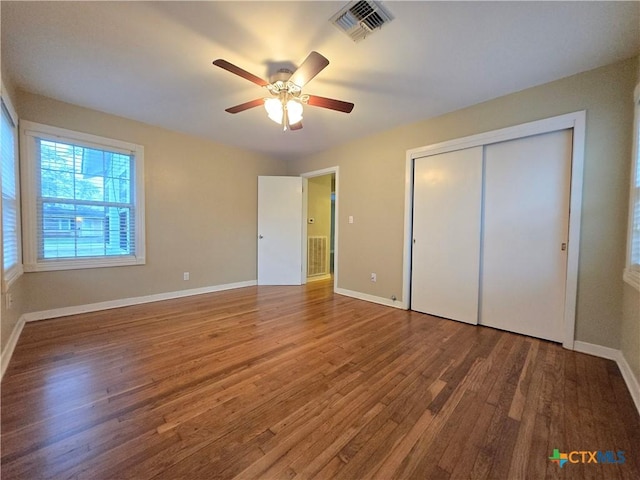 unfurnished bedroom with hardwood / wood-style floors, ceiling fan, and a closet