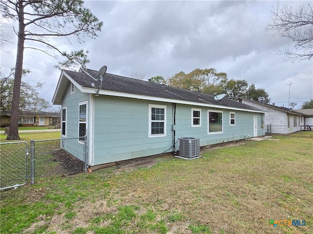 back of house with cooling unit and a yard