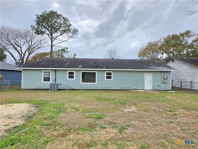 back of property featuring cooling unit and a lawn