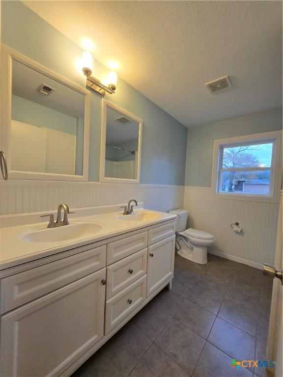 bathroom with vanity, tile patterned floors, a textured ceiling, and toilet