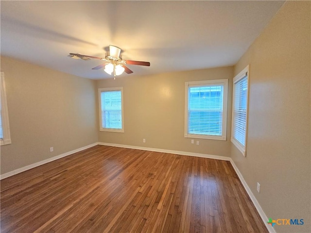 empty room with ceiling fan and hardwood / wood-style floors