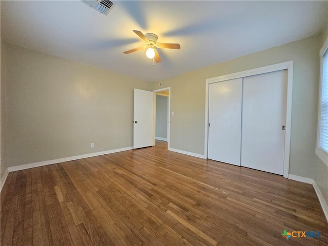 unfurnished bedroom with hardwood / wood-style floors, ceiling fan, and a closet