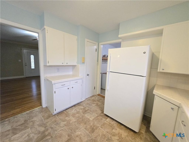 kitchen with white cabinetry, tasteful backsplash, and white refrigerator