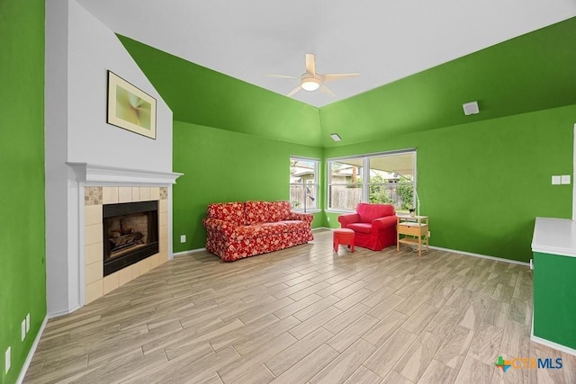 9100 Brimstone Ln, Austin, TX 78717 - living area with ceiling fan, light wood finished floors, lofted ceiling, a tiled fireplace, and baseboards