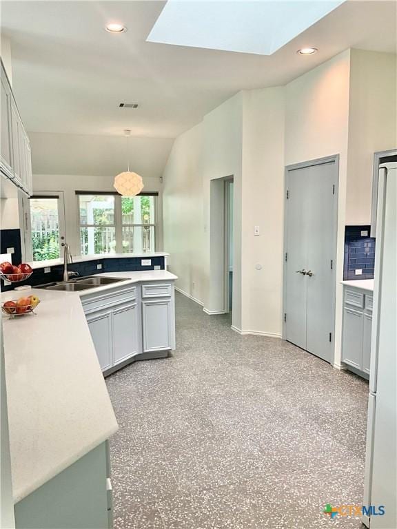9100 Brimstone Ln, Austin, TX 78717 - kitchen featuring a skylight, vaulted ceiling, light countertops, recessed lighting, and a peninsula