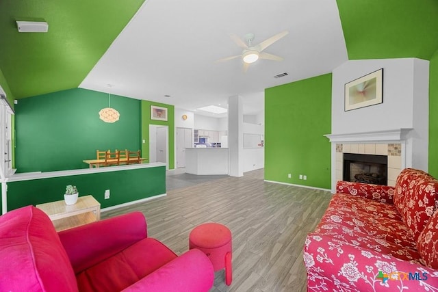 9100 Brimstone Ln, Austin, TX 78717 - living room featuring a ceiling fan, wood finished floors, baseboards, a fireplace, and lofted ceiling