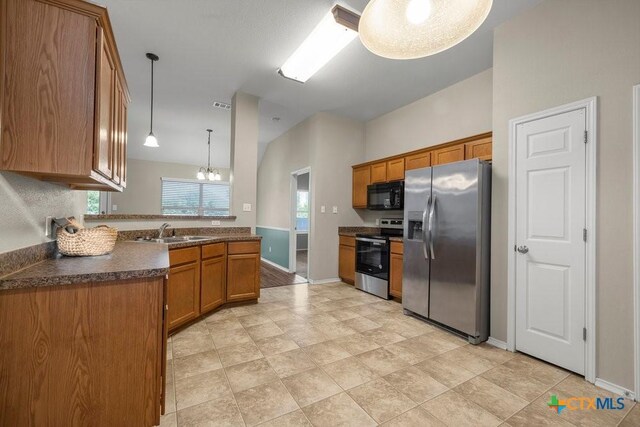 1117 Branchwood Way, Temple, TX 76502 - kitchen with appliances with stainless steel finishes, brown cabinets, dark countertops, pendant lighting, and a chandelier