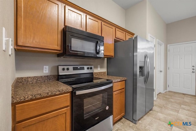 1117 Branchwood Way, Temple, TX 76502 - kitchen featuring electric range oven, black microwave, stainless steel refrigerator with ice dispenser, light tile patterned floors, and brown cabinets