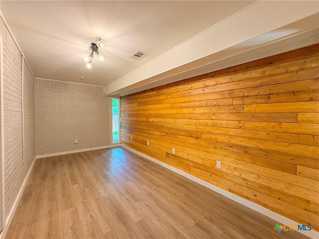 4310 Antelope Trl, Temple, TX 76504 - spare room with brick wall, wood finished floors, and wood walls