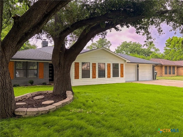 4310 Antelope Trl, Temple, TX 76504 - view of front facade with a garage, concrete driveway, a front yard, a chimney, and brick siding