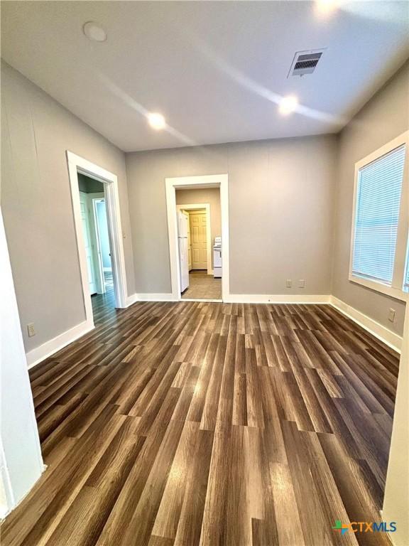 unfurnished room with dark hardwood / wood-style floors