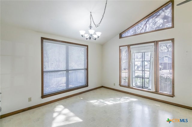 spare room with lofted ceiling, a notable chandelier, and baseboards