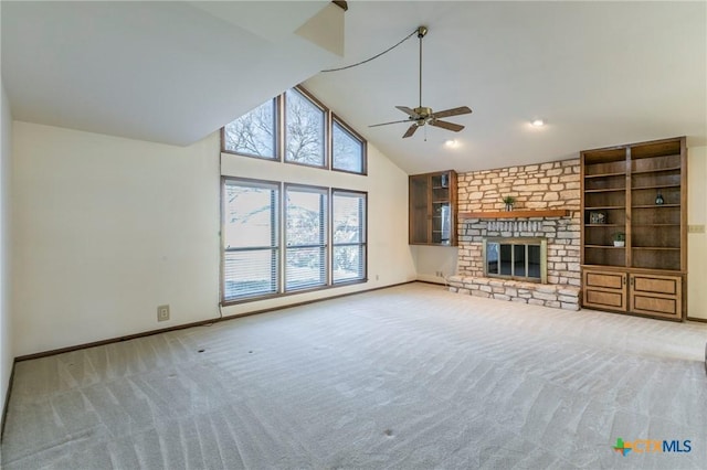 unfurnished living room featuring carpet floors, a brick fireplace, high vaulted ceiling, and baseboards