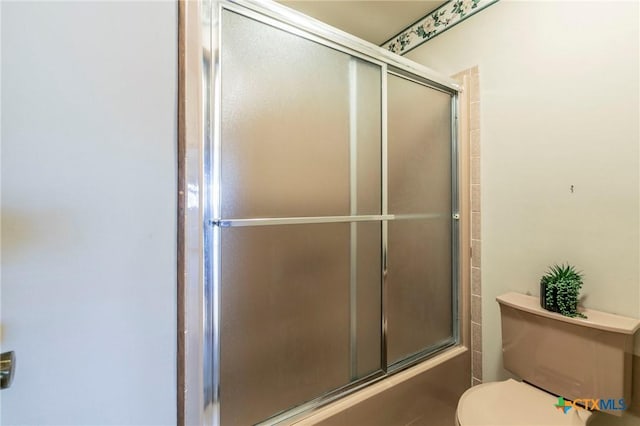 bathroom with shower / bath combination with glass door and toilet