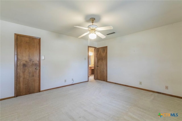 unfurnished room featuring light carpet, baseboards, visible vents, and ceiling fan