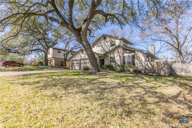 view of front of house with driveway, a front lawn, and fence