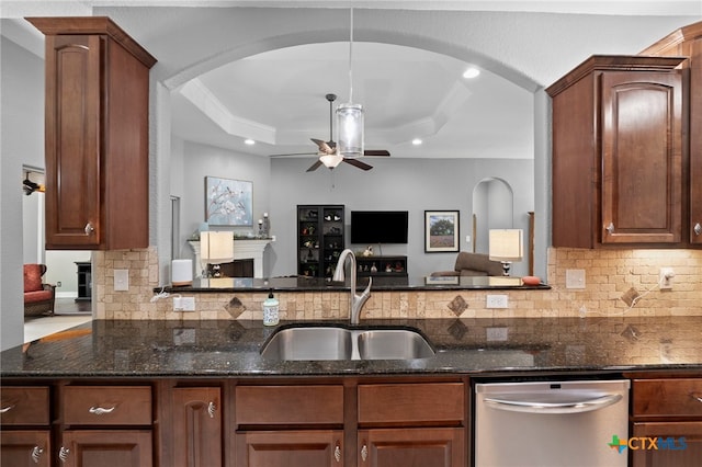 721 Gallagher Dr, Canyon Lake, TX 78133 - kitchen featuring a sink, stainless steel dishwasher, arched walkways, a raised ceiling, and crown molding