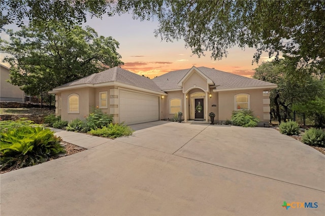 721 Gallagher Dr, Canyon Lake, TX 78133 - view of front of property with stucco siding, an attached garage, driveway, and a shingled roof