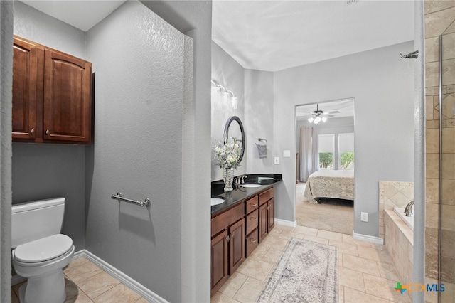 721 Gallagher Dr, Canyon Lake, TX 78133 - ensuite bathroom featuring double vanity, toilet, a relaxing tiled tub, ceiling fan, and baseboards