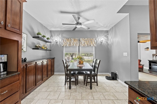 721 Gallagher Dr, Canyon Lake, TX 78133 - dining room with ceiling fan, a textured ceiling, and baseboards