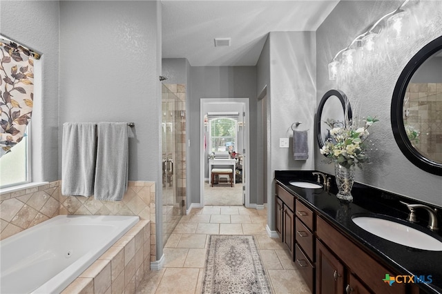 721 Gallagher Dr, Canyon Lake, TX 78133 - bathroom featuring a stall shower, a whirlpool tub, double vanity, tile patterned flooring, and a textured wall