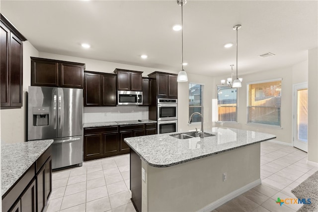 kitchen with stainless steel appliances, sink, pendant lighting, a chandelier, and an island with sink