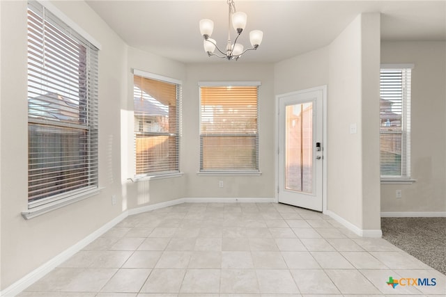 unfurnished dining area featuring light tile patterned floors and a chandelier