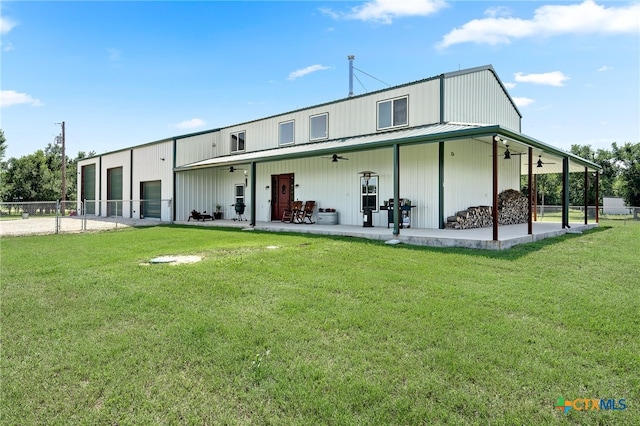 back of house with ceiling fan, a yard, and a patio