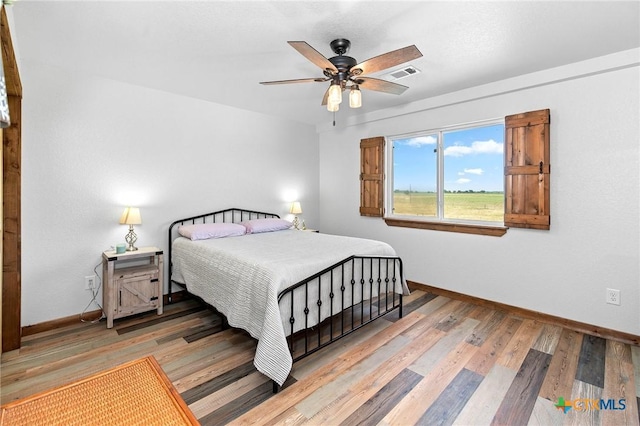 bedroom with light hardwood / wood-style flooring and ceiling fan