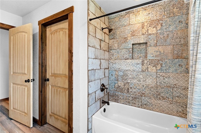 bathroom with shower / bath combination, a textured ceiling, and hardwood / wood-style flooring