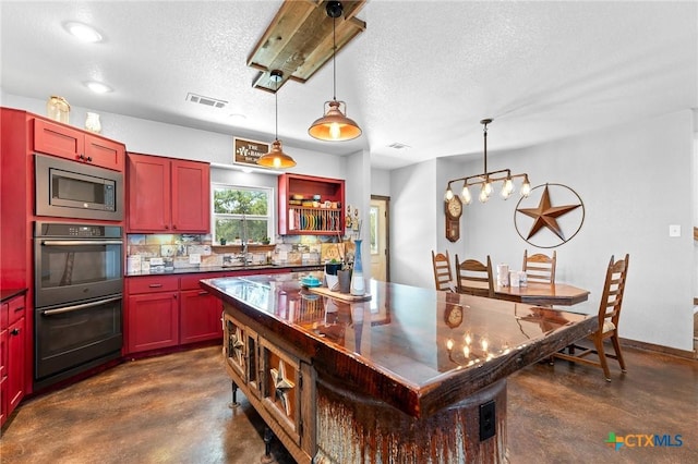 463 County Road 436, Thorndale, TX 76577 - kitchen featuring finished concrete flooring, stainless steel microwave, double wall oven, dark countertops, and a textured ceiling