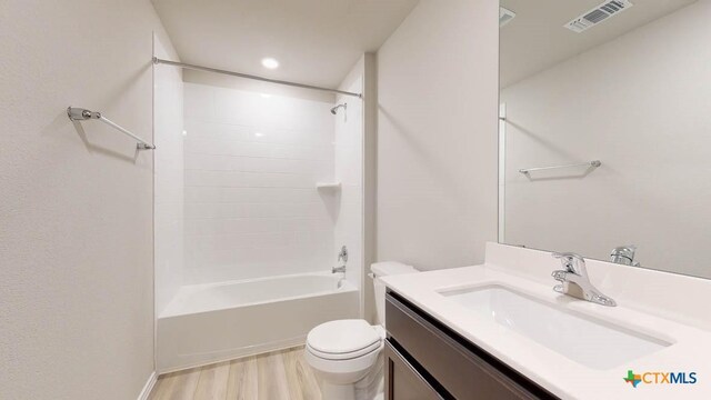 full bathroom featuring hardwood / wood-style floors, vanity, toilet, and washtub / shower combination