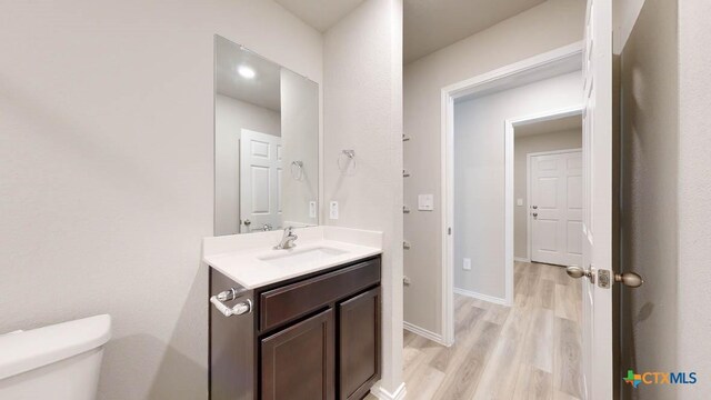 bathroom featuring hardwood / wood-style floors, vanity, and toilet